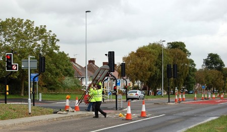 Workers remove traffic cones and signage to bring a new bus lane into operation.
